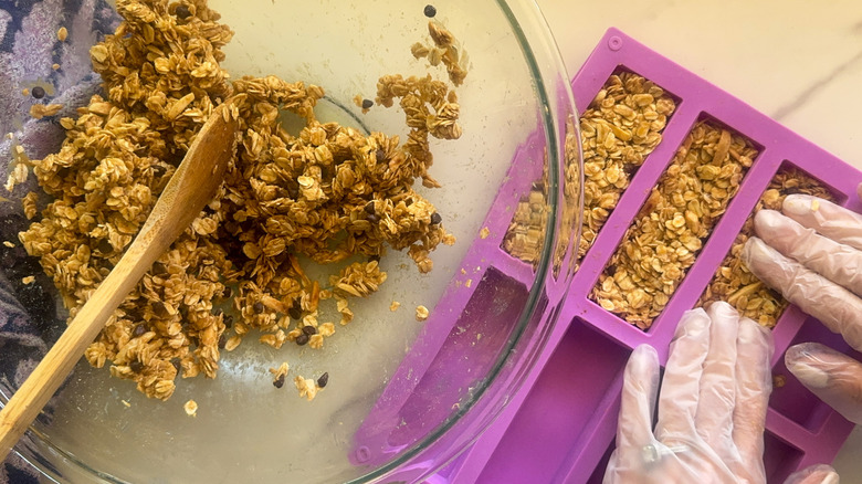 mains pressant le mélange dans le moule