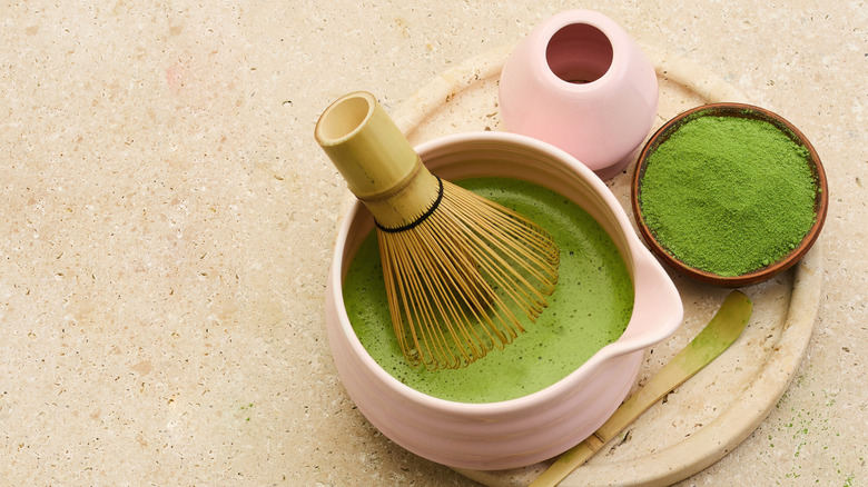 Le matcha est préparé dans un bol de cérémonie, avec de la poudre de matcha dans un bol.