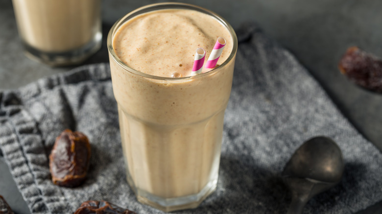 un milk-shake aux dattes avec deux pailles à rayures rouges