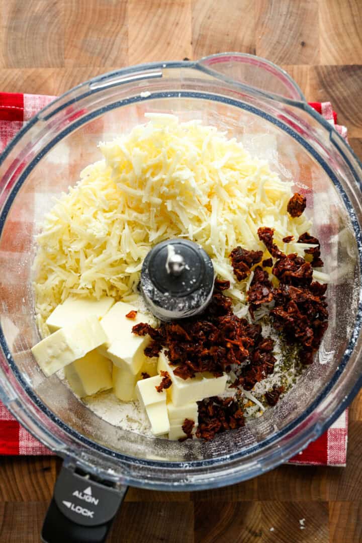 Vue aérienne des ingrédients du fromage dans un robot culinaire.