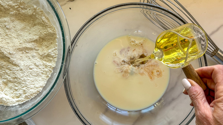 main versant de l'huile dans un bol