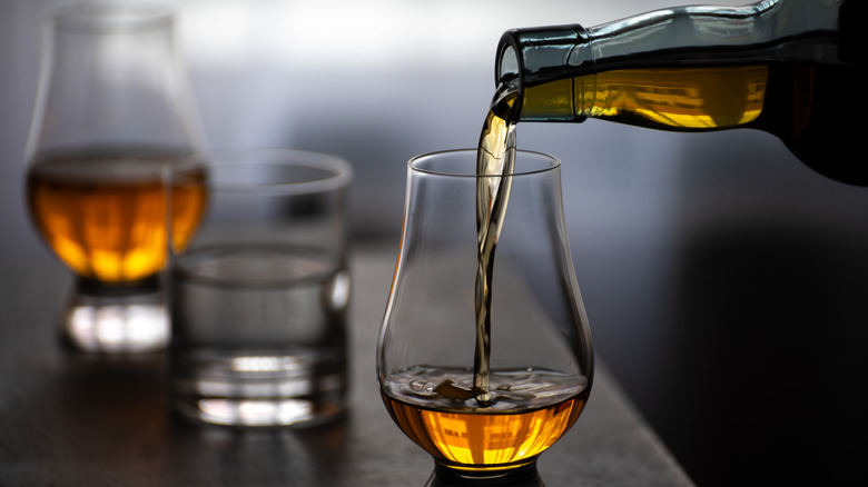 Scotch versé dans un verre à côté de l'eau sur le comptoir.