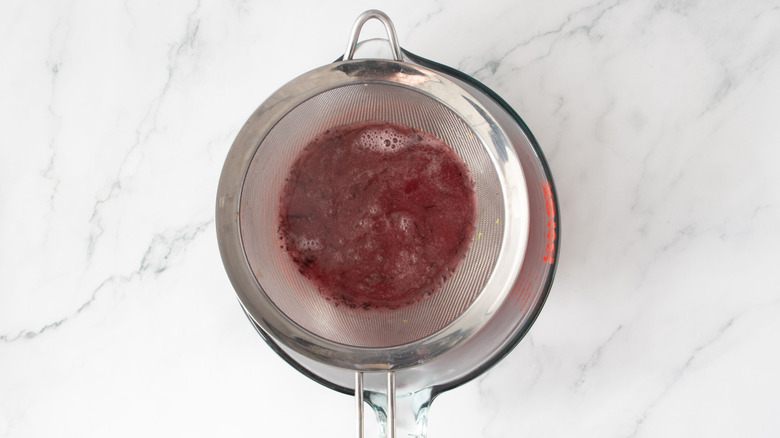 Jus de canneberge assis dans une passoire