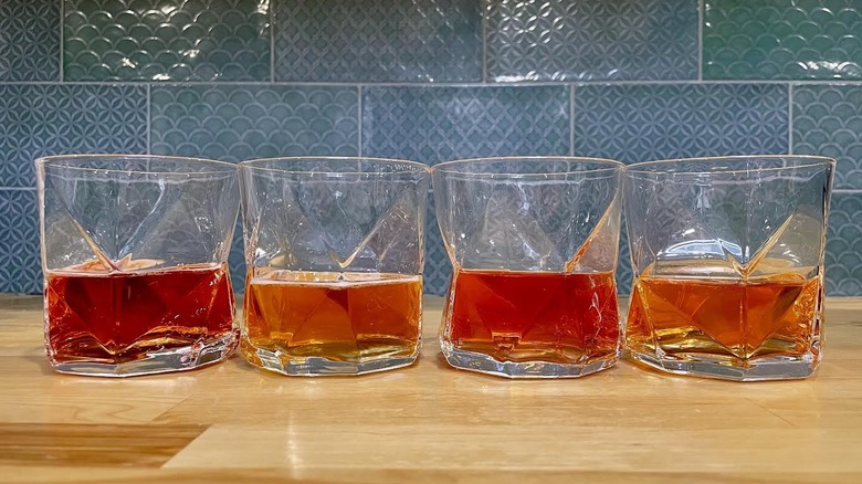 Quatre verres de boissons protéinées Beyond Immerse sur un comptoir en bois