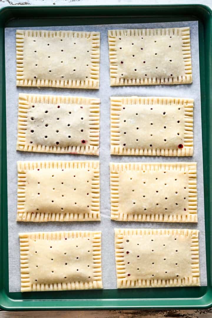 8 pop tartelettes sur une plaque à pâtisserie avant la cuisson. 