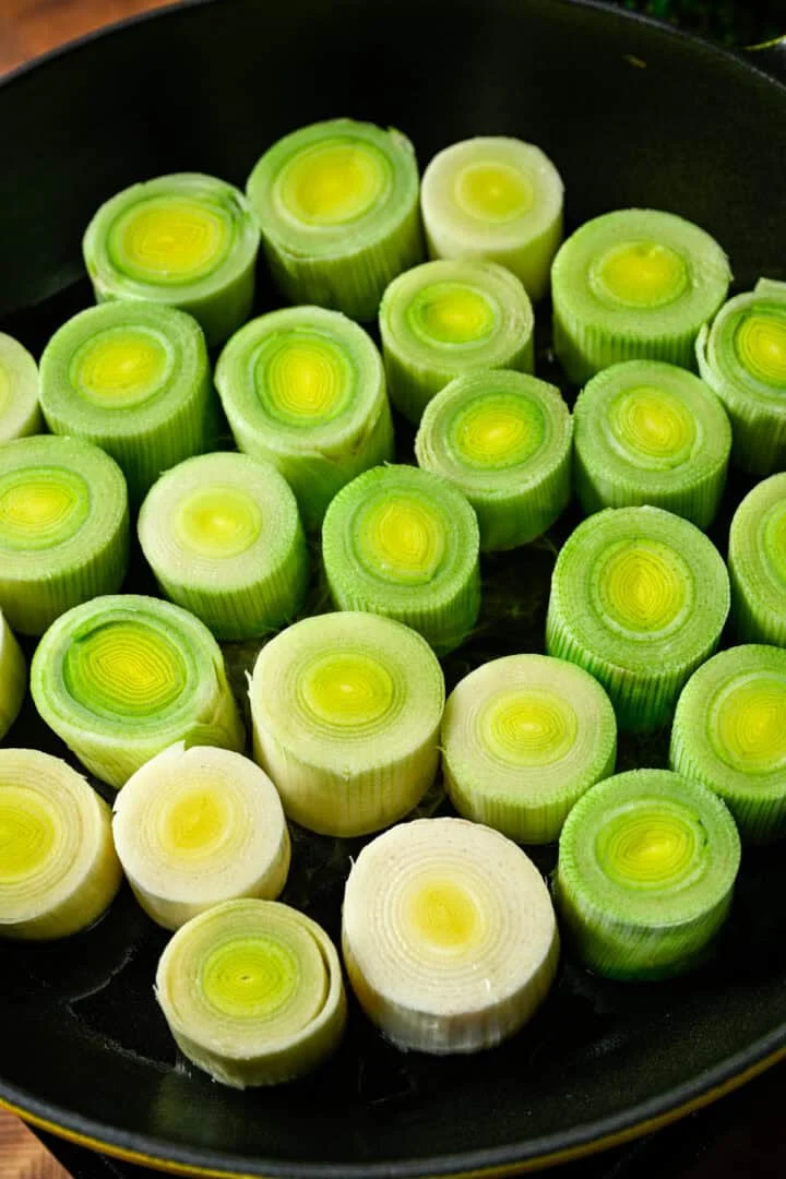 Vue aérienne de poireaux crus dans une poêle.