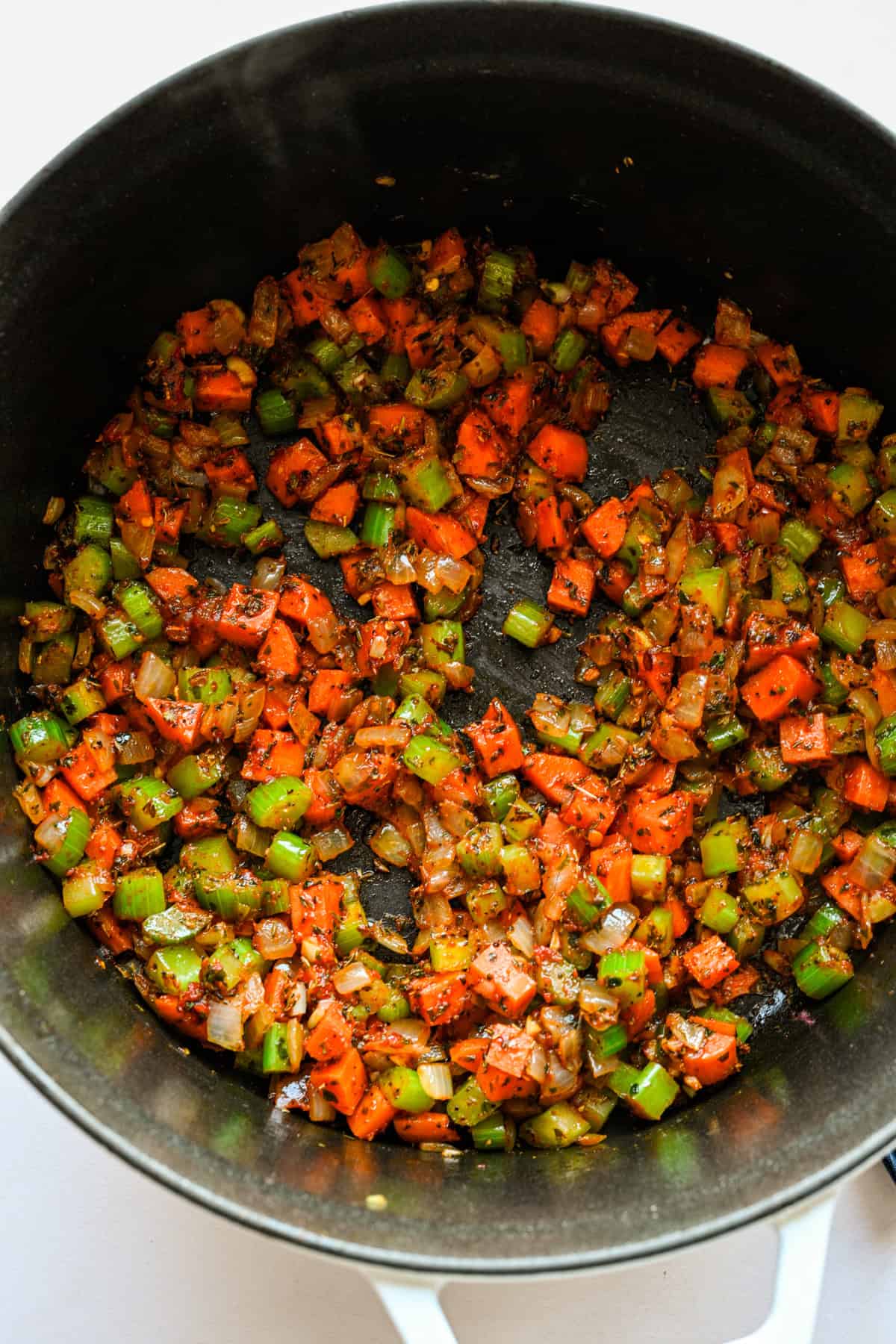 Pâte de tomate et assaisonnements ajoutés aux légumes dans la marmite.