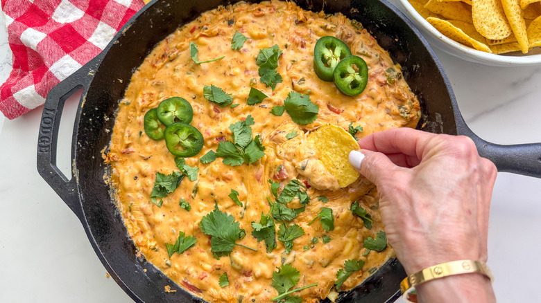 tremper à la main dans une poêle avec des frites