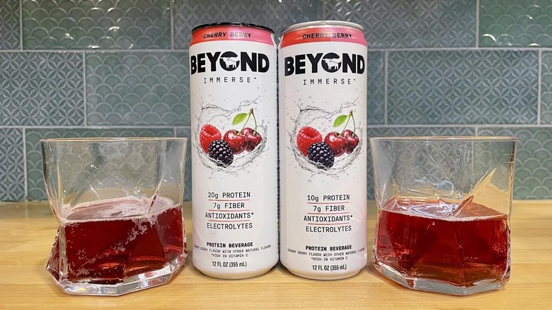 Canettes et verres de Beyond Immerse Cherry Berry sur le comptoir