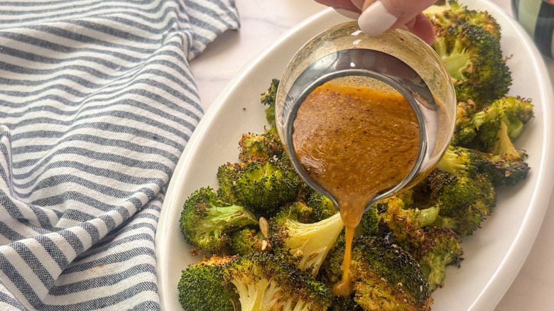 verser à la main la vinaigrette sur le brocoli