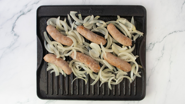 Gosses mijotés et oignon dans la bière sur une grande poêle à griller