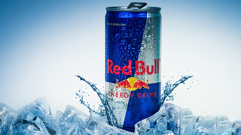Une canette de Red Bull posée sur de la glace sur fond bleu