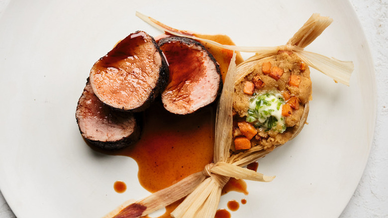 Filet de porc tranché sur une planche à découper en bois.