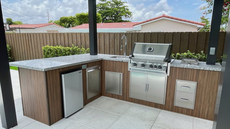Installation d'un bar extérieur dans une cour avec mini-réfrigérateur et grill