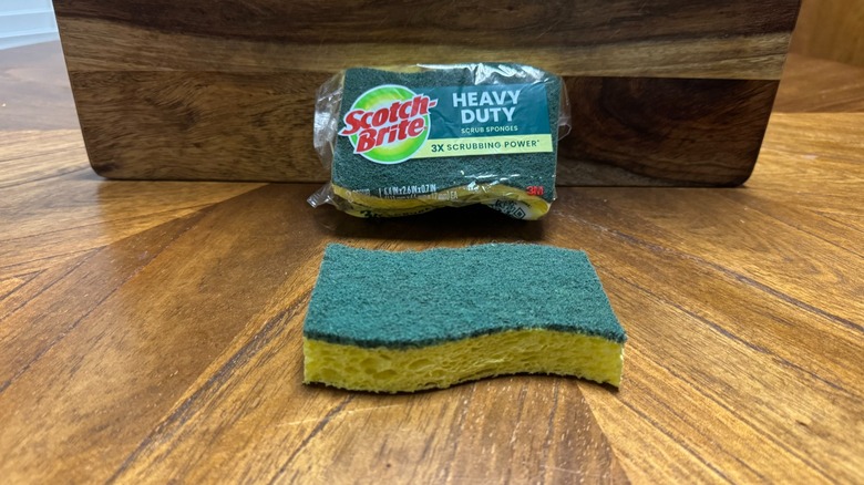 Un paquet d'éponges Scotch-Brite avec un fond en bois