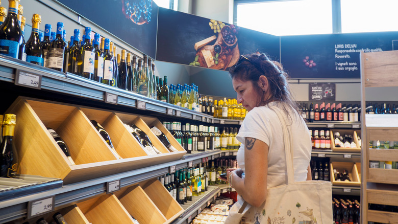 Une femme fait ses courses au rayon alcool d'Aldi