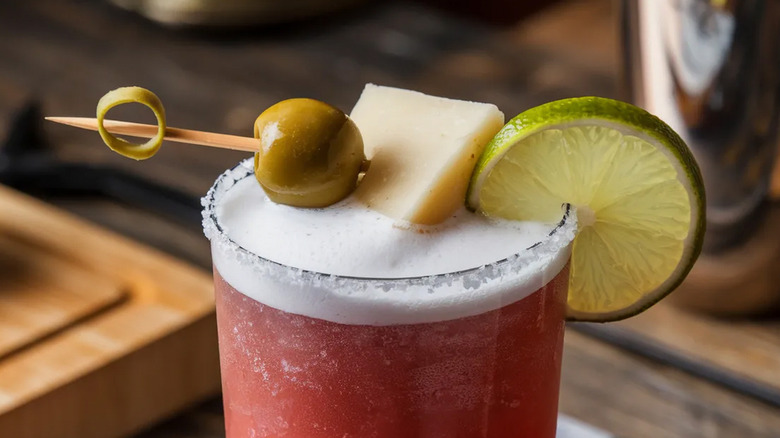 Une olive rejoint les garnitures du Bloody Mary.