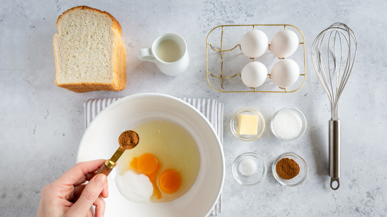 Les ingrédients du pain perdu comme le pain, les œufs et le lait sont soigneusement disposés sur un comptoir.
