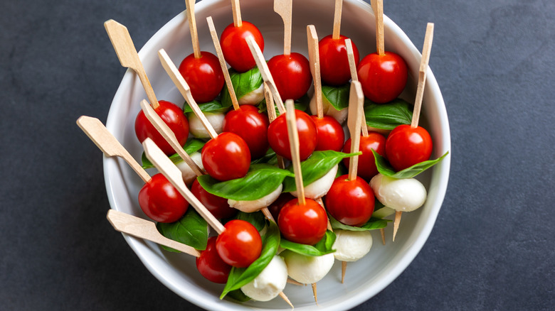 Les brochettes Caprese sont composées de tomates cerises, de mozzarella et de basilic.