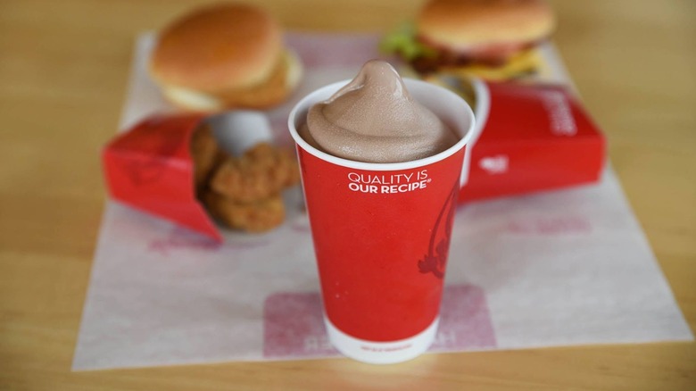 Un Wendy's Chocolate Frosty devant des burgers et des nuggets de poulet chez Wendy's