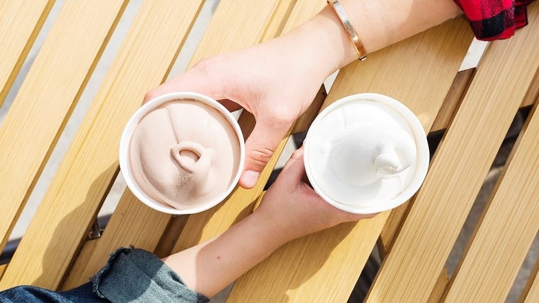 Deux mains tenant Wendy's Chocolate et Vanilla Frostys