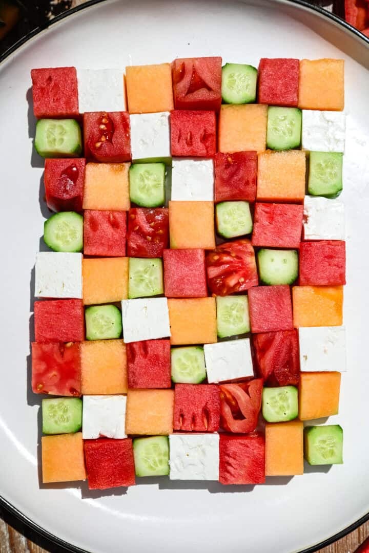 vue aérienne de la salade en damier de pastèque avec des carrés de melon, de concombre, de tomate et de feta.