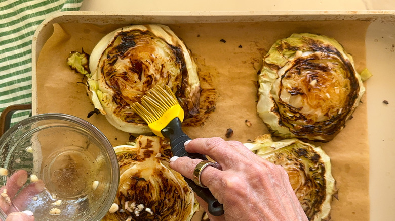 badigeonner à la main les steaks de chou rôti avec de l'huile