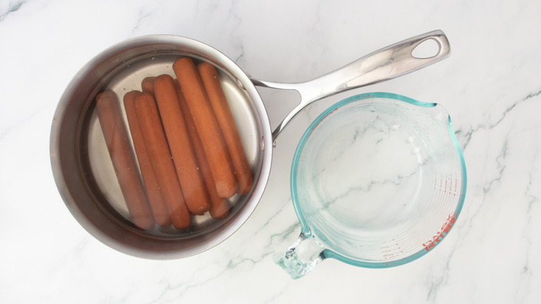 Hot dogs dans une grande casserole recouverte d'eau
