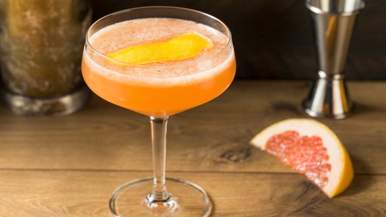 Un cocktail Brown Derby avec un pamplemousse en arrière-plan