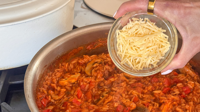 main ajoutant du parmesan