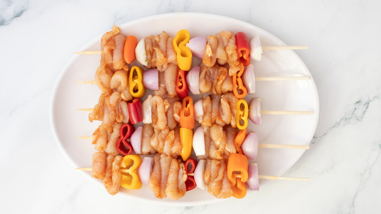 Poulet cru et légumes enfilés sur des brochettes de bambou