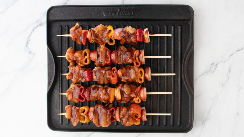 Brochettes de poulet et légumes sur une poêle à griller