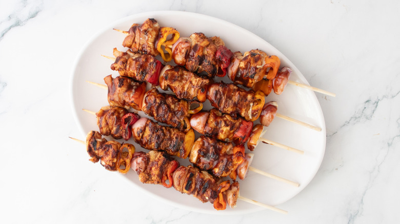 Brochettes de barbecue grillées sur un grand plateau blanc