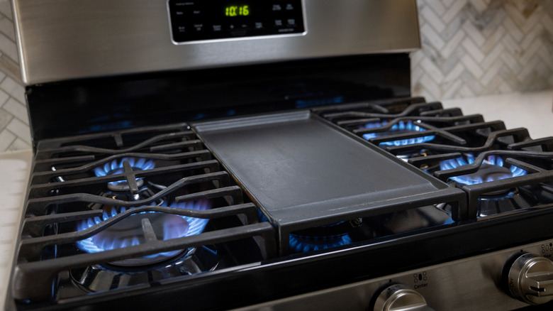 Une cuisinière à gaz avec tous les brûleurs allumés.