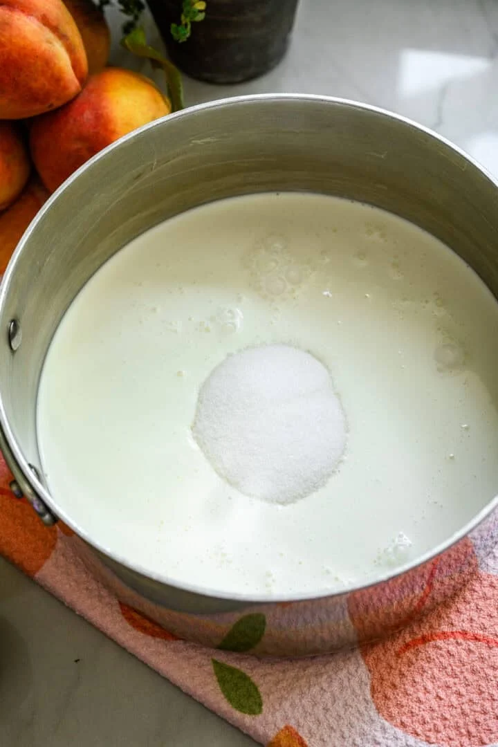 Crème épaisse, lait et sucre dans une casserole.