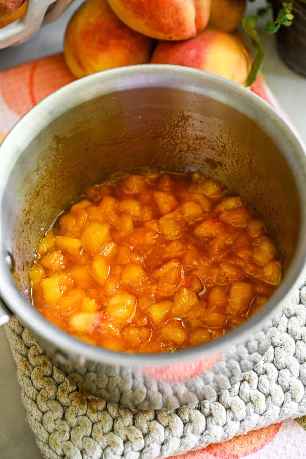 Vue aérienne de la compote de pêches dans une casserole en acier inoxydable.