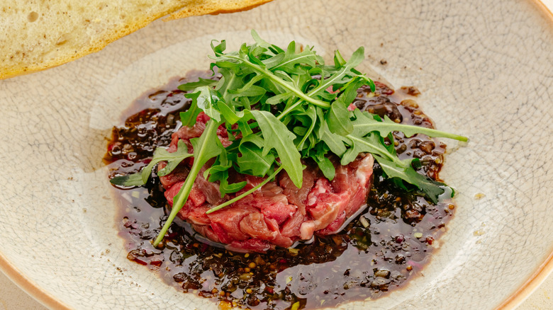 Une assiette de tartare de bœuf avec garniture fraîche