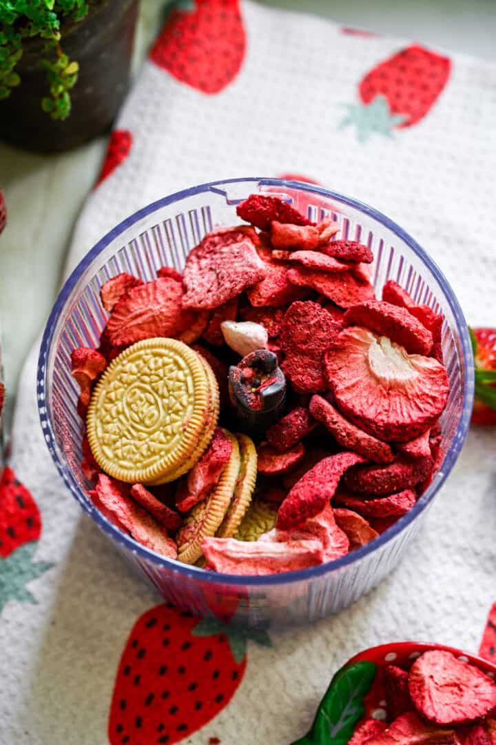 congeler les fraises séchées et les biscuits à la vanille dans un robot culinaire avant de les mélanger. 
