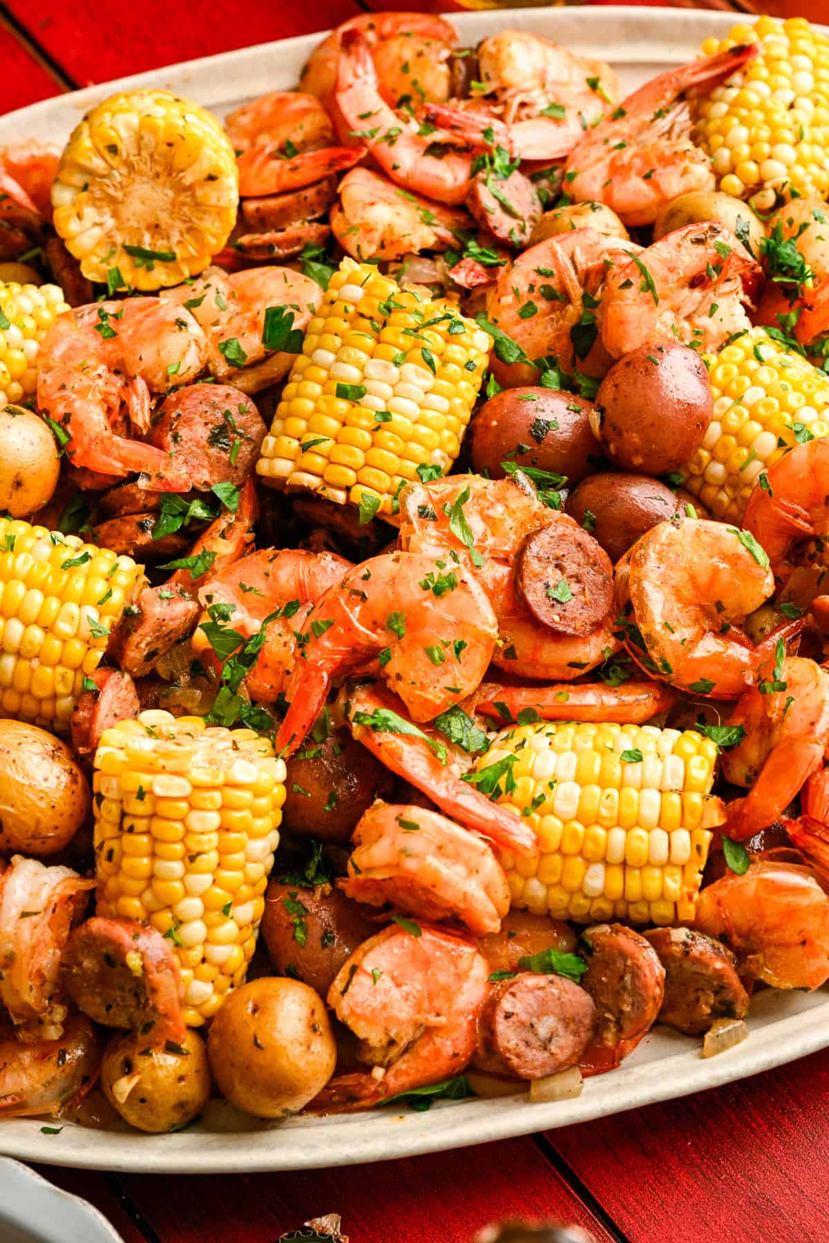 Vue rapprochée de l'ébullition des crevettes sur une assiette avec du maïs, des crevettes, des saucisses et des pommes de terre.
