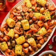 Vue aérienne de la poêle à feuilles de crevettes bouillie sur un plateau avec du maïs, des crevettes, des saucisses et des pommes de terre.