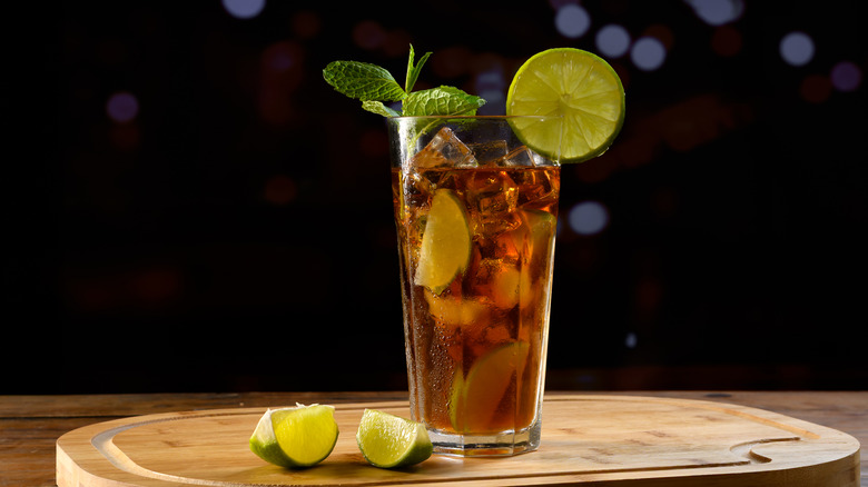 Un Cuba libre garni de citron, citron vert et menthe