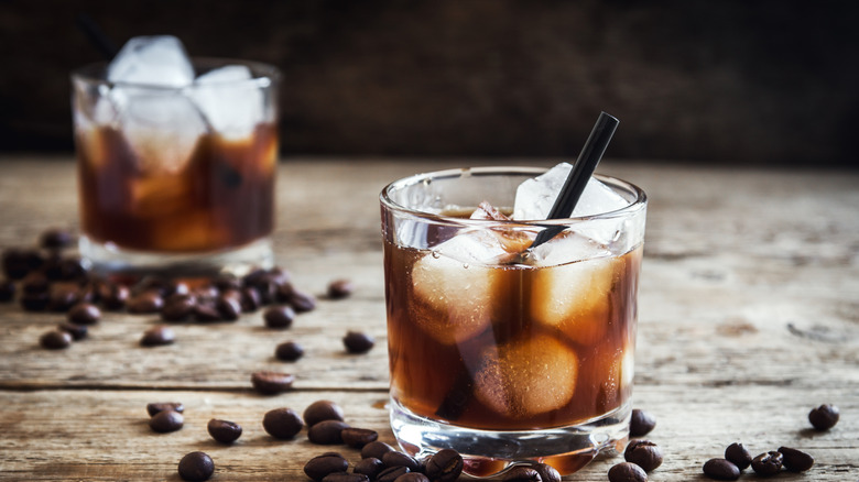 Cocktails russes noirs servis sur glace entourés de grains de café entiers