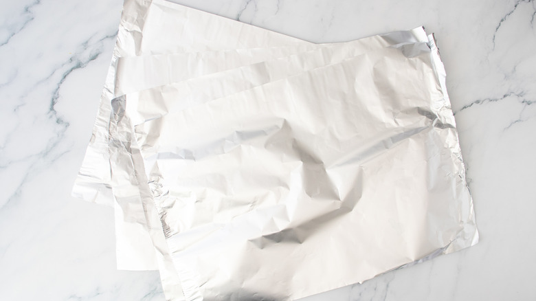 Quatre grandes feuilles de papier d'aluminium