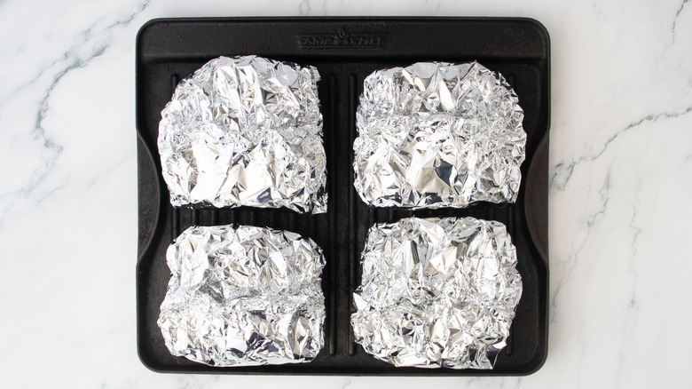 Quatre paquets de papier d'aluminium sur une lèchefrite
