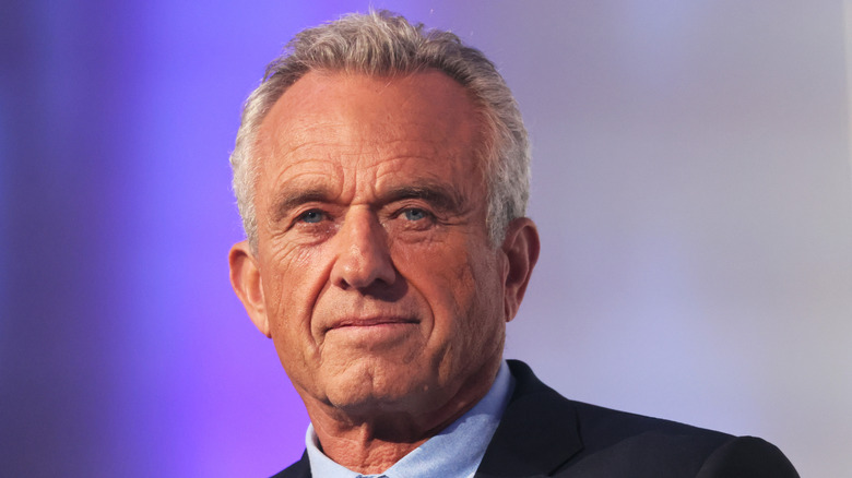 Une photo portrait de Robert F. Kennedy Jr. sur fond violet.