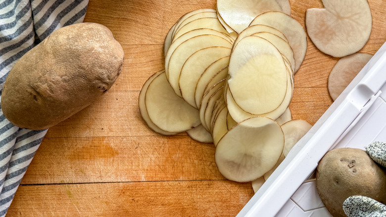 tranches de pommes de terre à côté de la mandoline