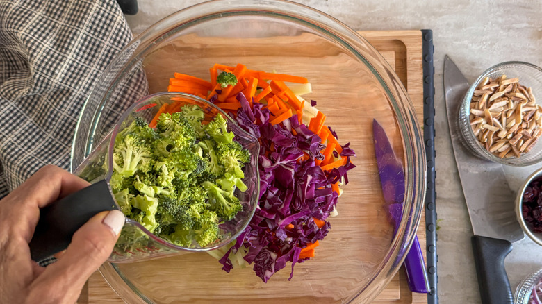 ajouter à la main le brocoli dans un bol avec d'autres ingrédients de la salade de chou