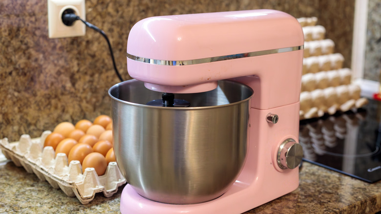 Batteur sur socle rose sur un comptoir en marbre