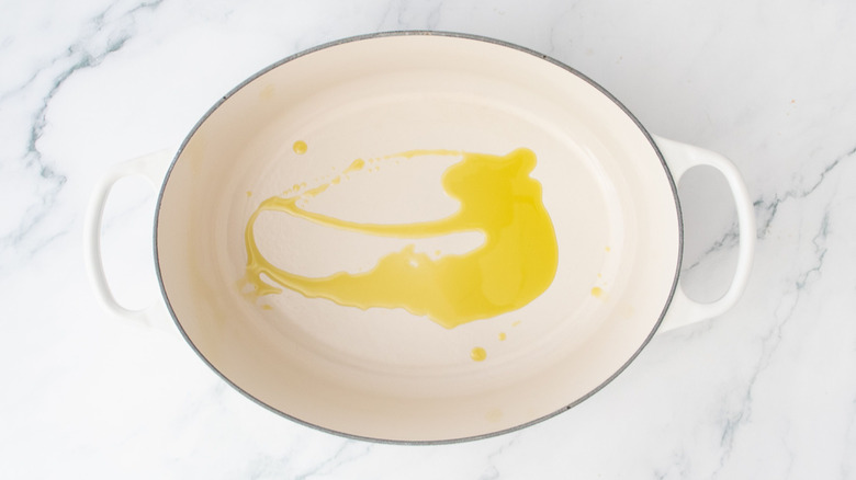 Un filet d'huile d'olive dans une grande cocotte