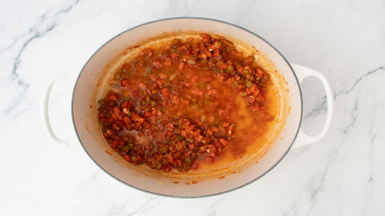 Légumes coupés en dés enrobés de pâte de tomate avec du liquide au four hollandais